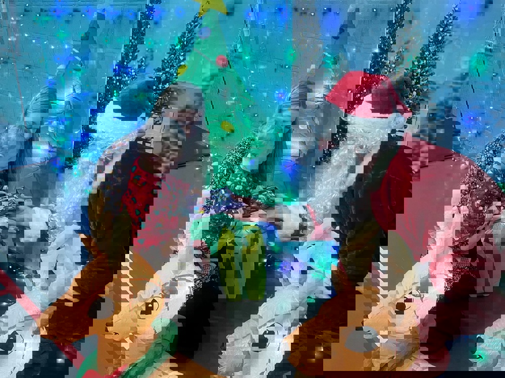 Sion Corn yn rhoi anrheg i plentyn bach 